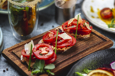 seitenansicht-bruschetta-mit-tomaten-basilikum-fruhlingszwiebeln-und-parmesan-auf-einem-brett - Gastronomie Objekt mit vielseitigen Nutzungsmöglichkeiten in Bellheim